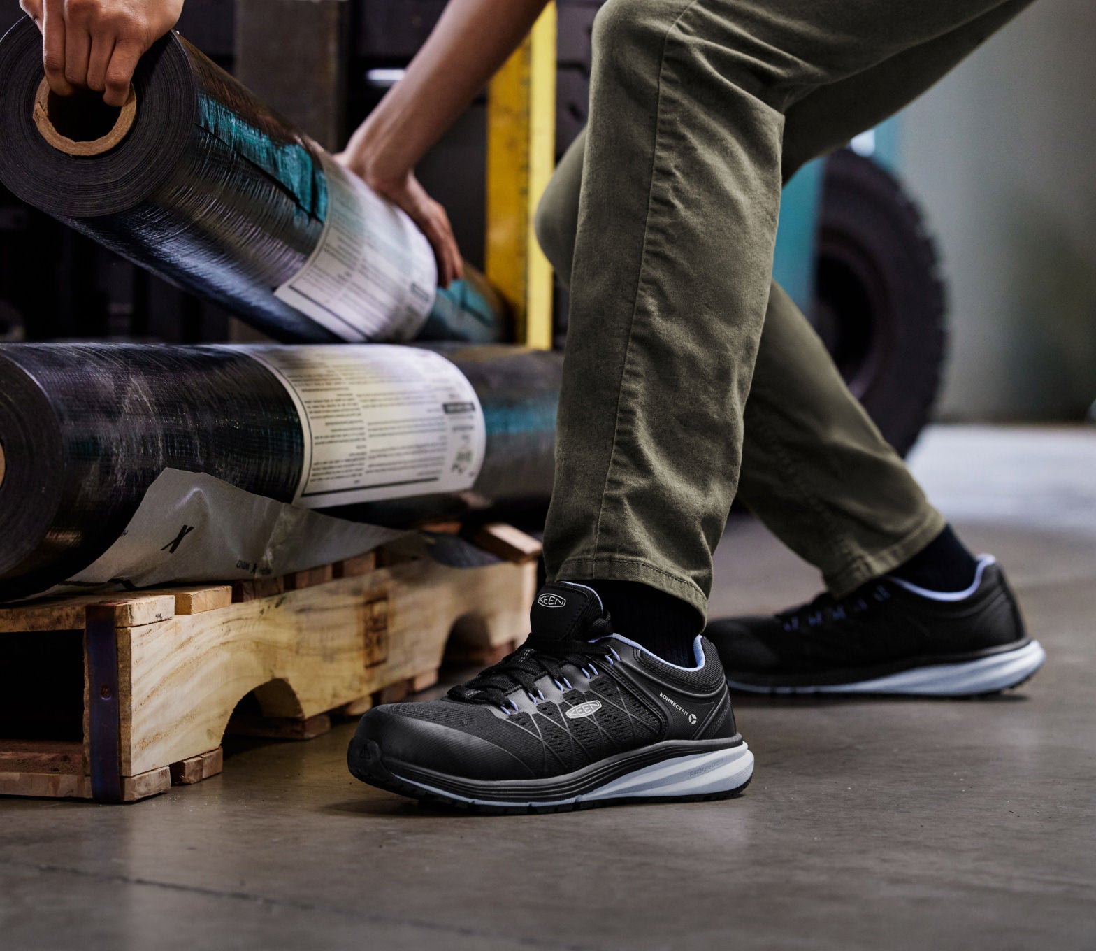 Knee down view of man wearing vista energy and stacking material on a wood palette