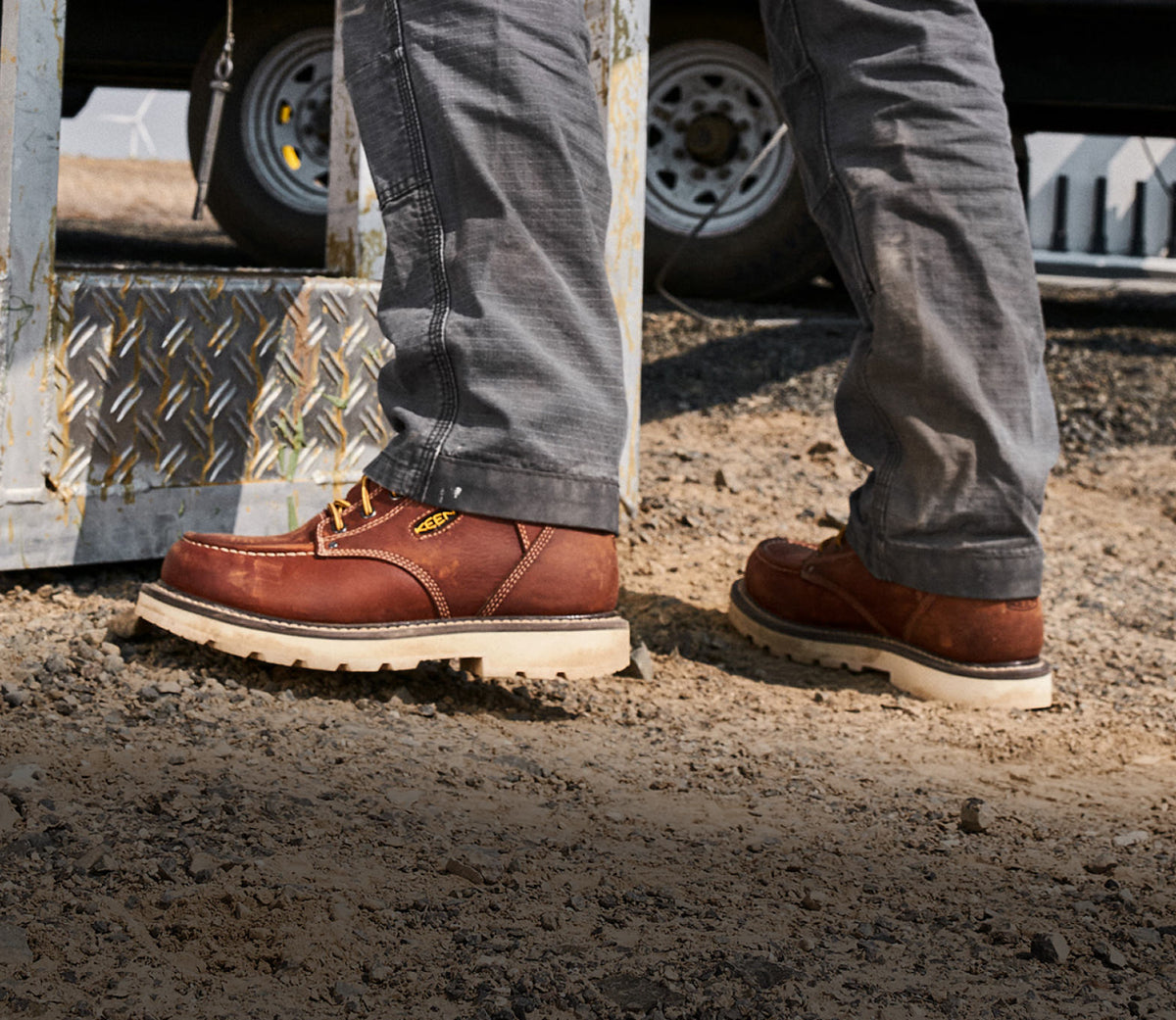 Waist down shot of man wearing Cincinnati work boots and jeans standing on dirt surface