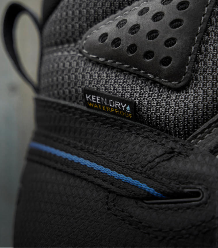 A close-up of a black KEEN work shoe featuring KEEN.DRY waterproof material.