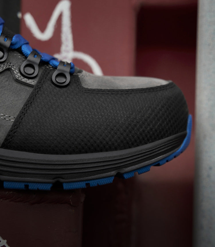 A close-up of the toe of a black and blue KEEN work sneaker.