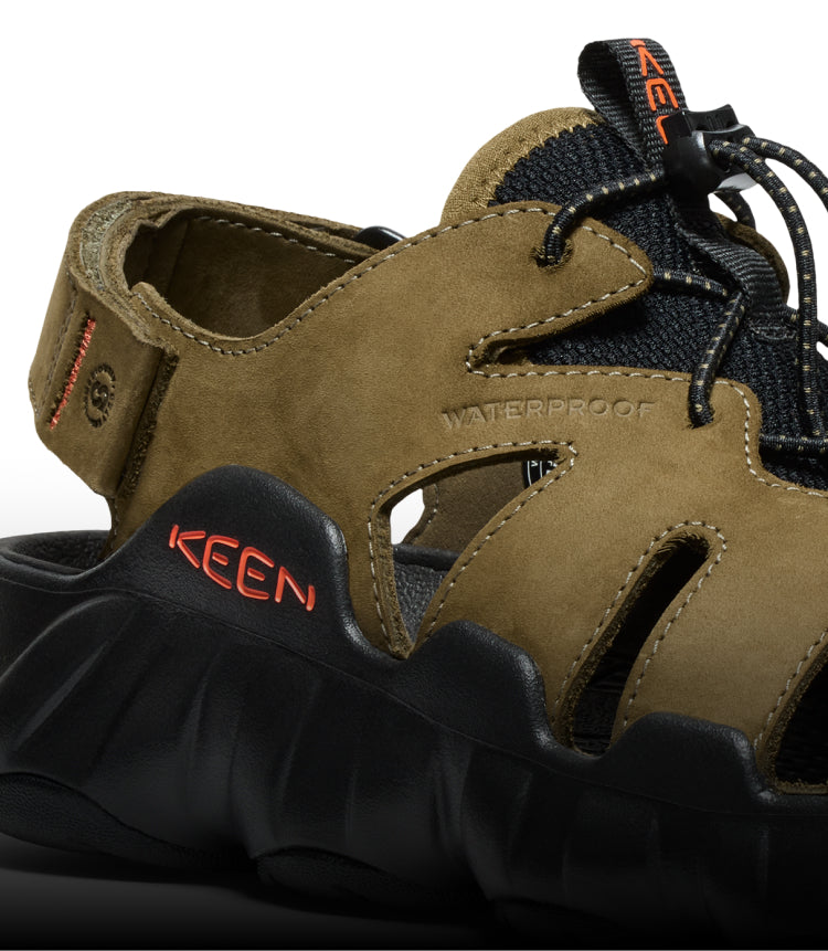 A close-up of a black and olive green KEEN sandal.