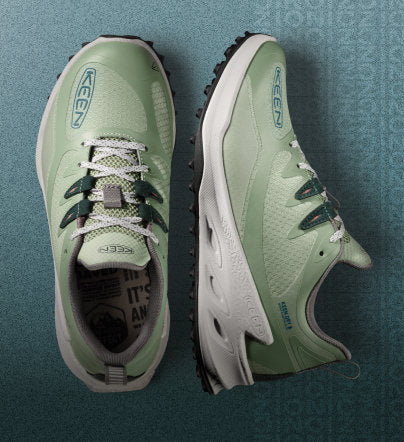 Close up of Zionic hiking shoes on teal, gradient background
