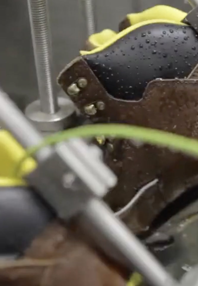 Work boot attached to machinery being tested in ice water