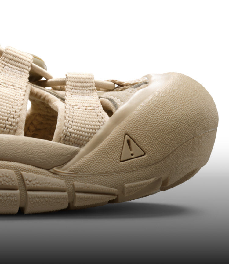 A close-up of a cream-colored Newport H2 sandal.