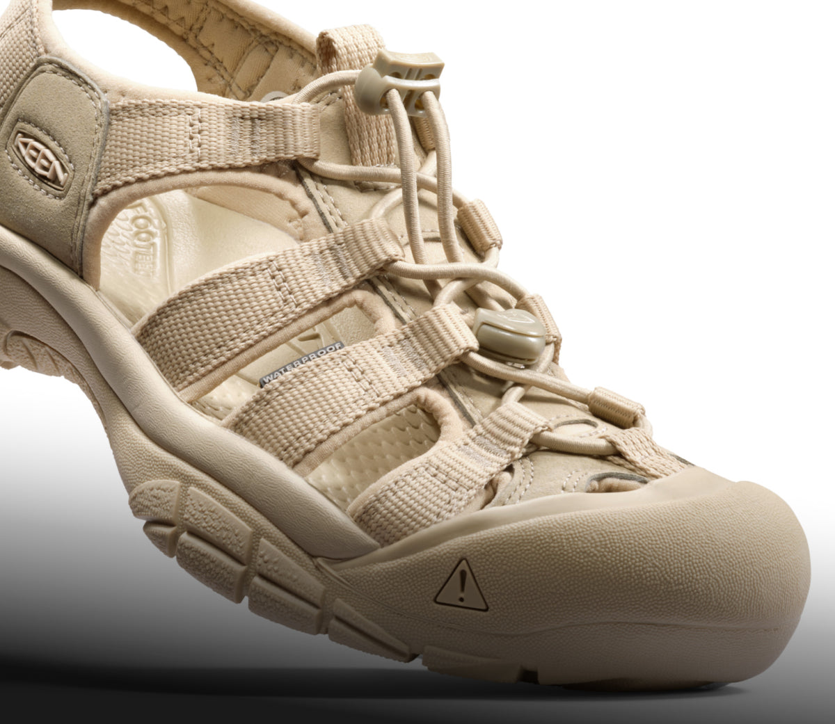 A close-up of a cream-colored Newport H2 sandal.