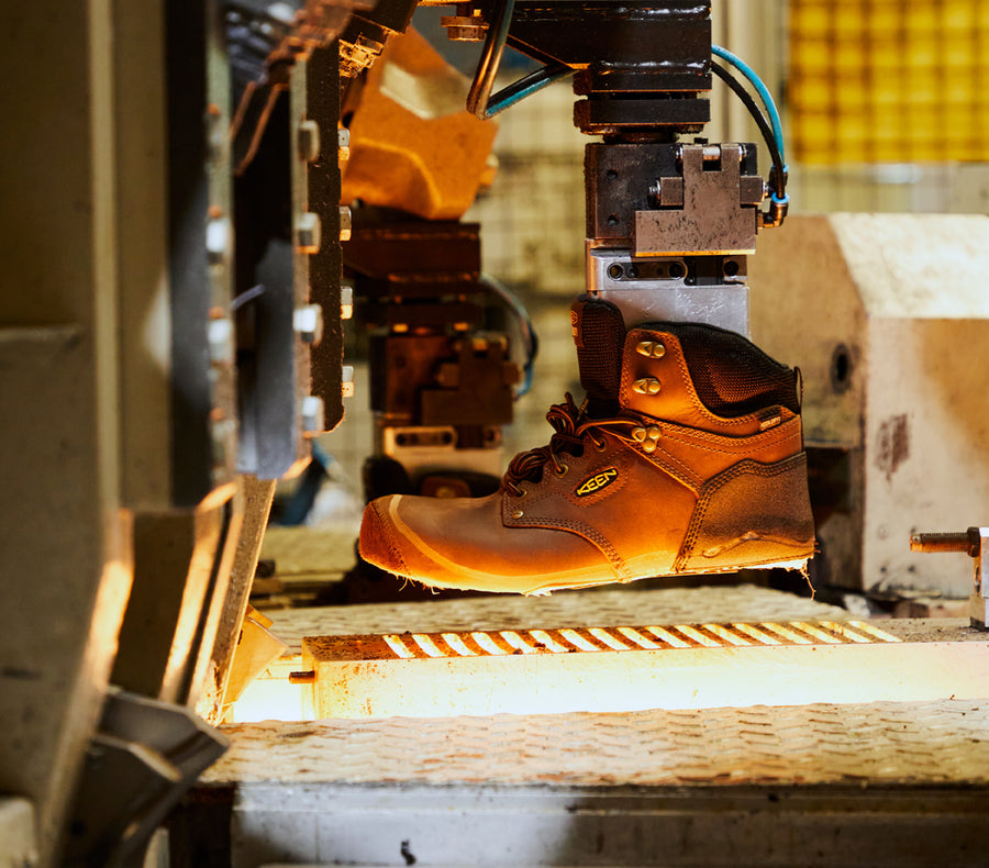 A pair of KEEN work boots being manufactured with machinery.