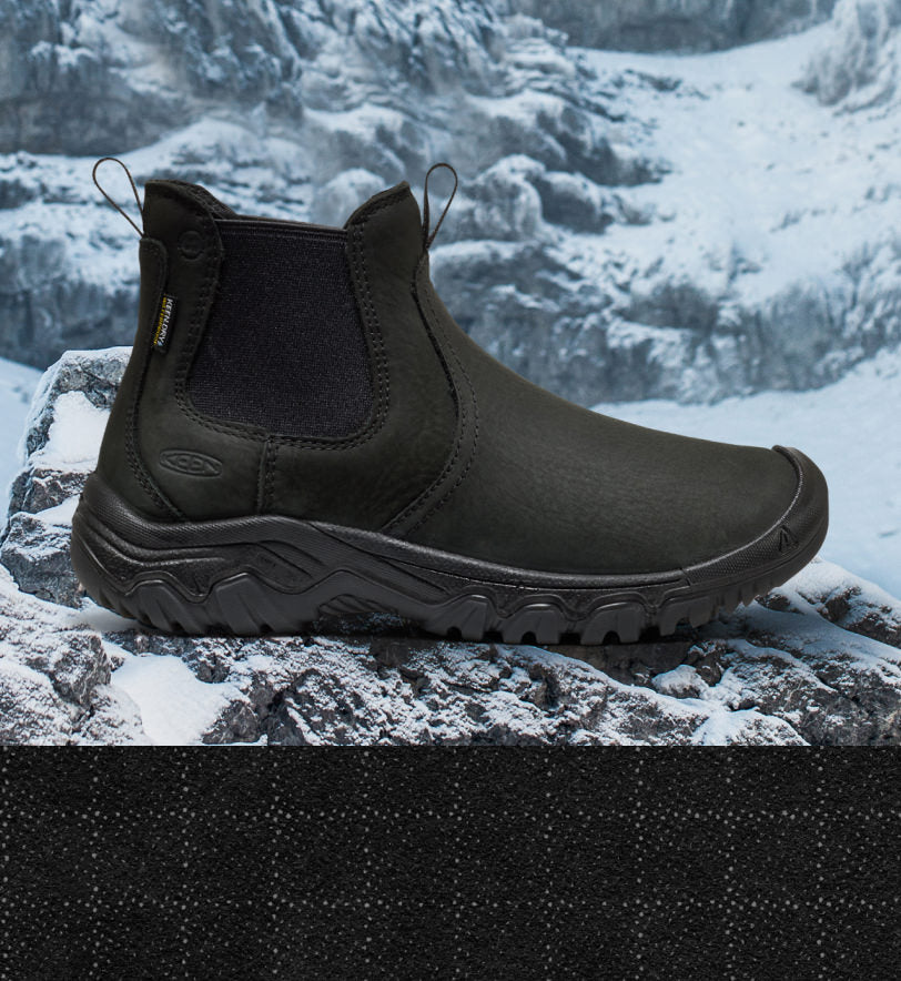 Product shot of women's black insulated boot with icy glacier background. 