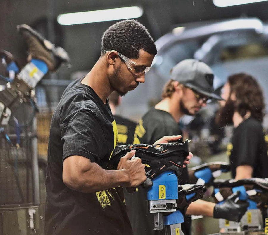 A man manufacturing a pair of KEEN work boots with machinery.