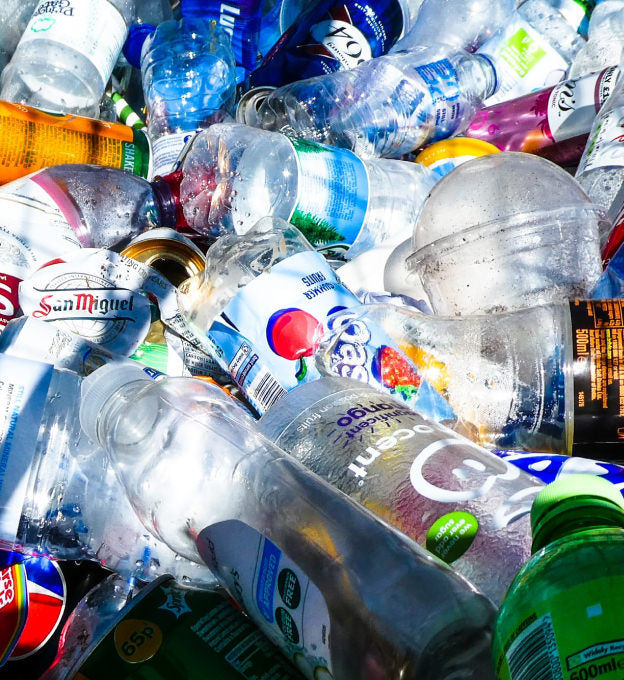 various empty bottles and cans in a large pile